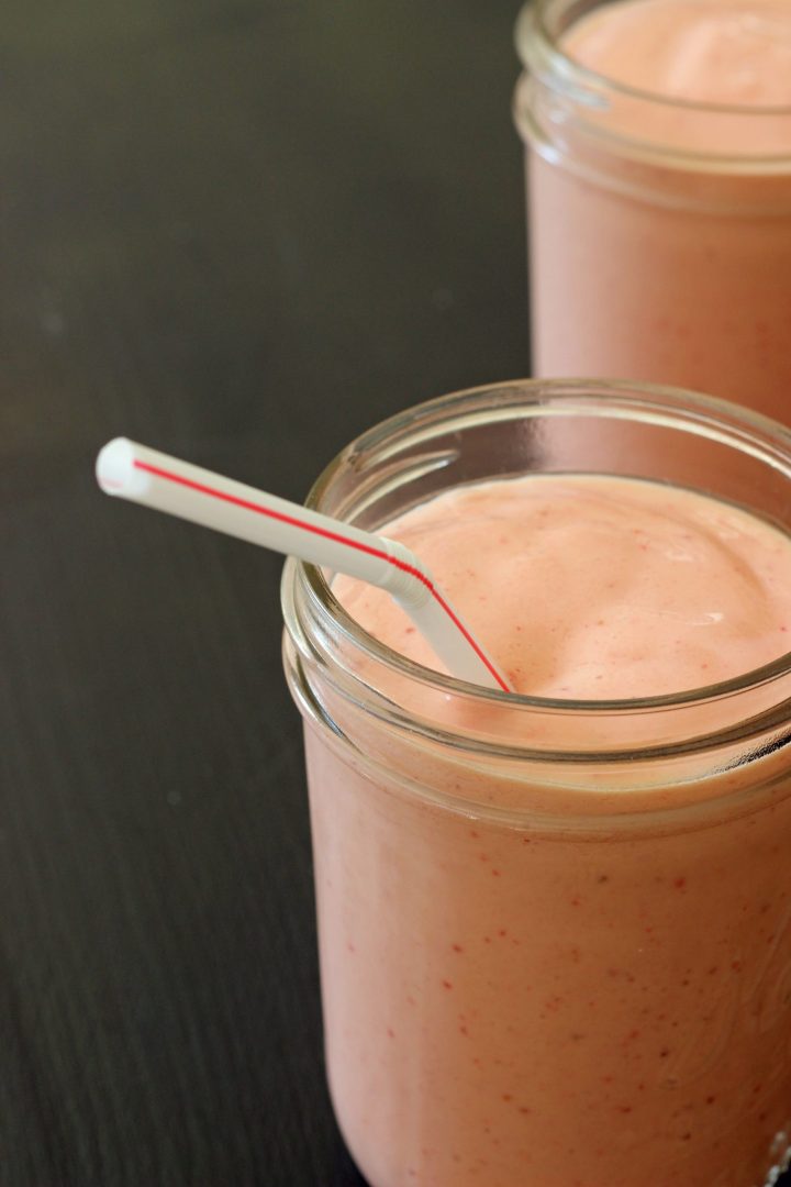 mason jars with strawberry smoothie and straws