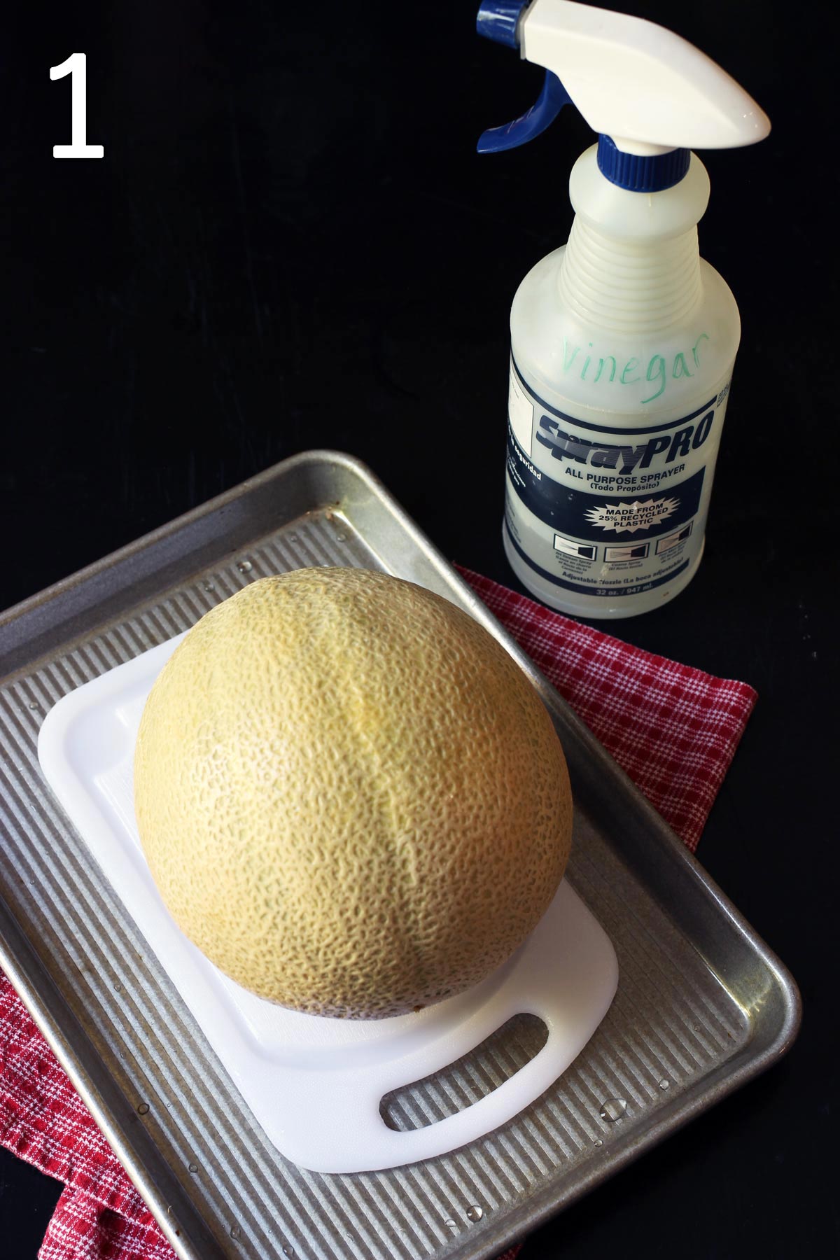 melon on tray with spray bottle of vinegar nearby.