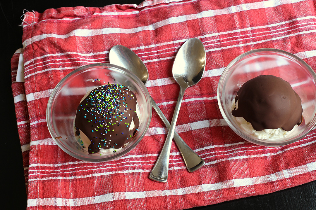 red cloth with two bowls of sundaes with magic shell