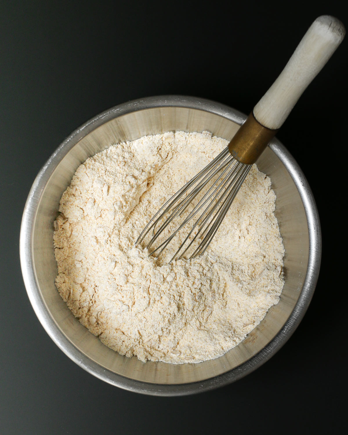 a whisk submerged into the combined ingredients in the bowl.