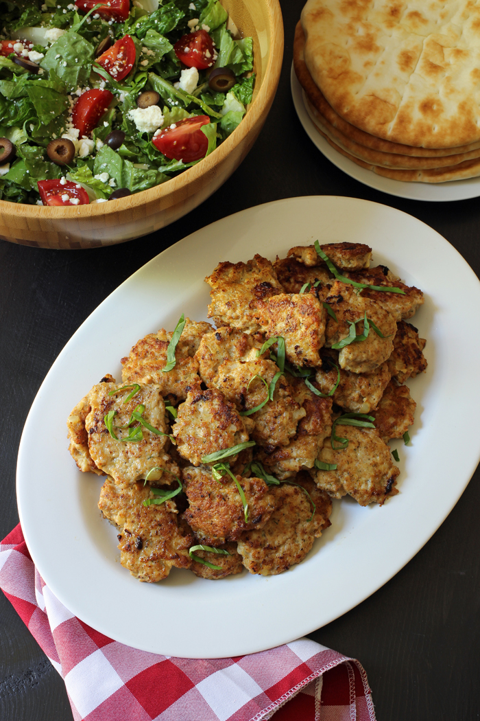 Chicken Patties on platter with salad and pita bread