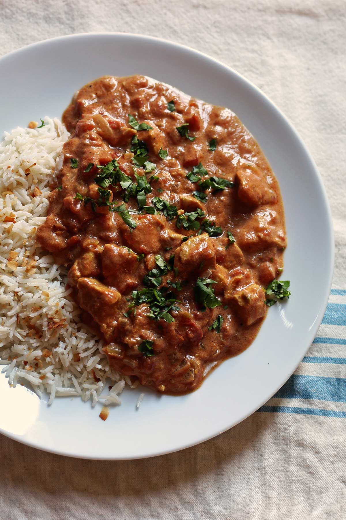 plate of coconut rice and chicken tikka masala.