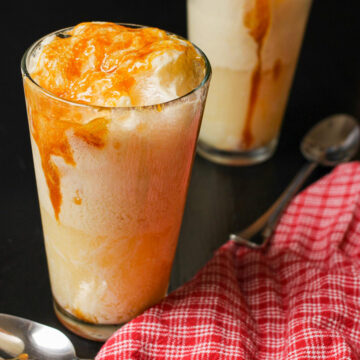 close up of sparkling apple cider float with caramel drizzle on top of the foam.