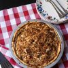 apple pie on checked cloth with plates and forks
