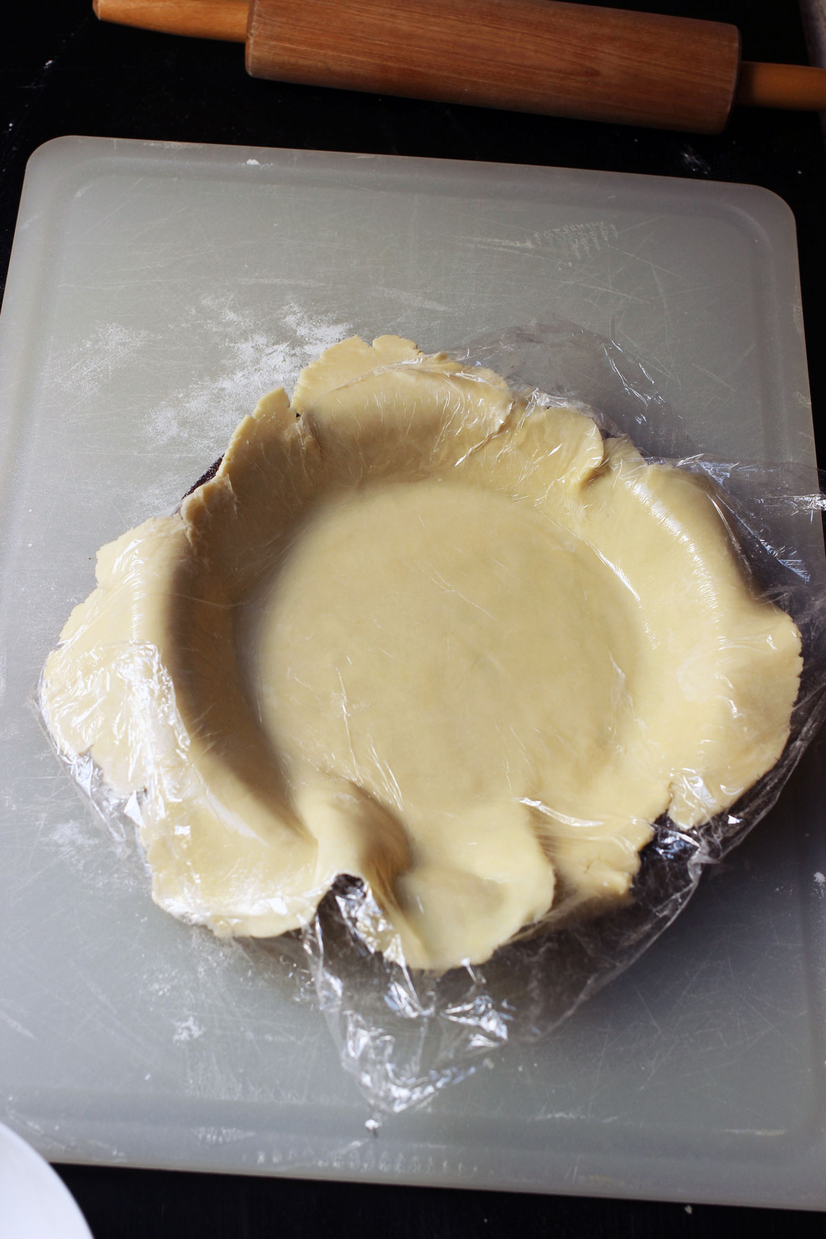 fitting pie dough with plastic wrap