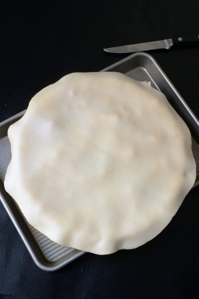 fitting top crust on pie