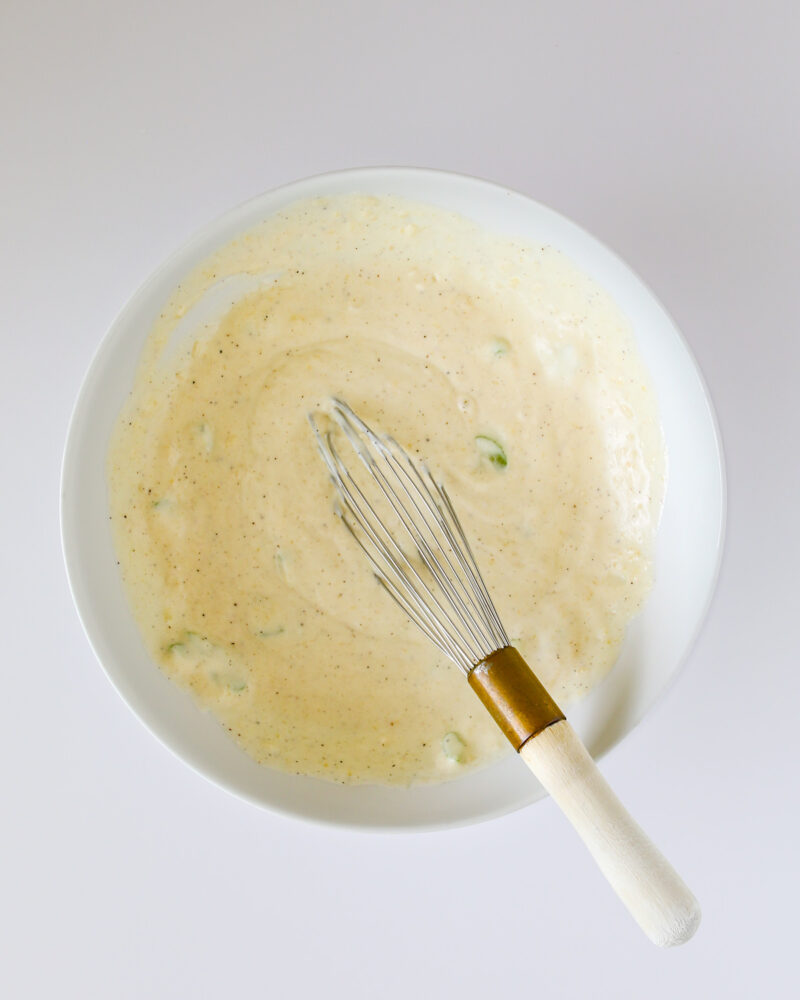 sauce ingredients with a whisk in mixing bowl.