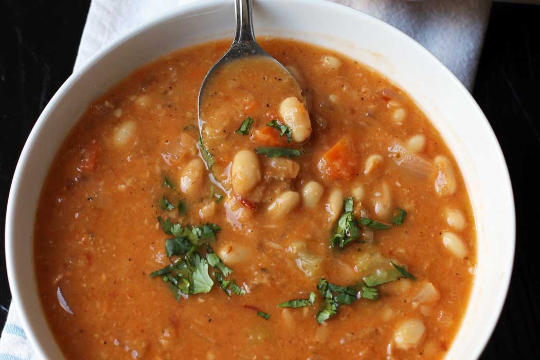 spoonful of bean soup resting on side of the bowl