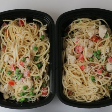 pasta prepped in black meal prep dishes.