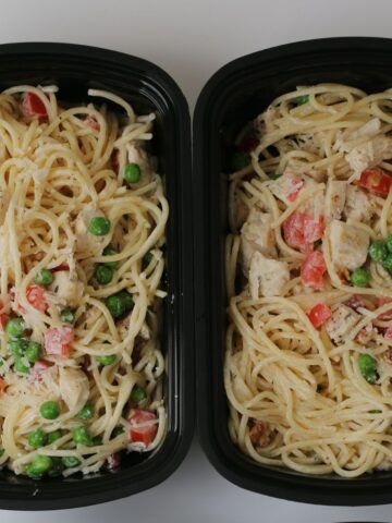 pasta prepped in black meal prep dishes.