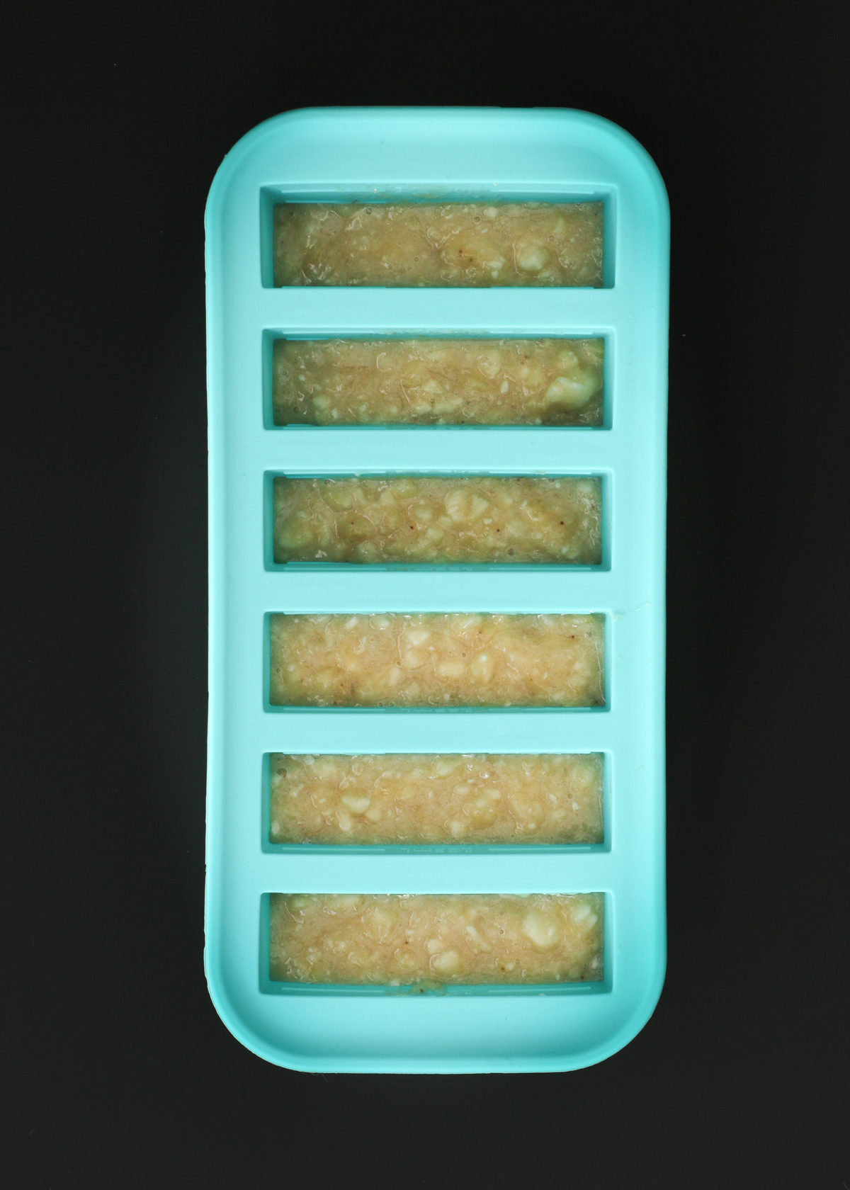 banana puree in small compartments of a souper cubes tray.