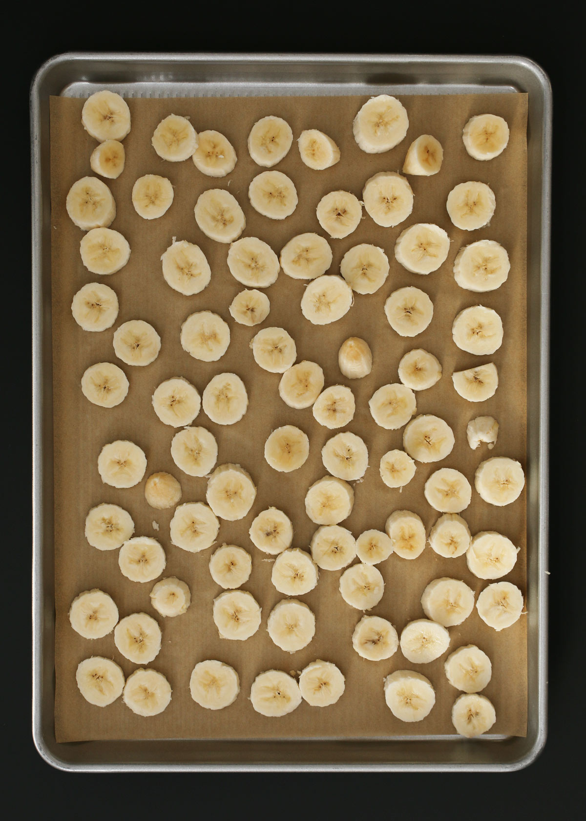 frozen banana slices on lined baking sheet.