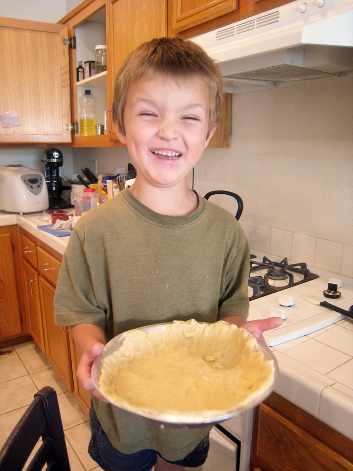 preschool boy holding pie crust he made himself