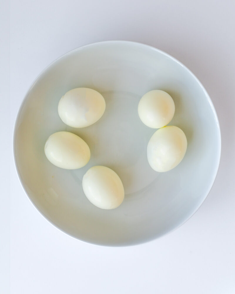 hard cooked eggs, peeled and assembled in a dish.