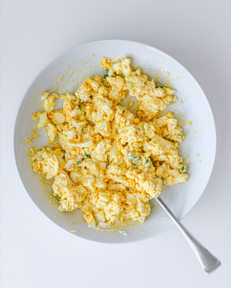 the completed egg salad in the dish, with a fork.