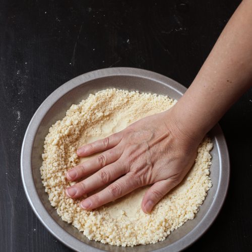 Premium Photo  Close-up cooking process. women's hands hold plate of flour  in her hands and add it with spoon to bowl with ingredients. on the table  cookie molds and baking molds.