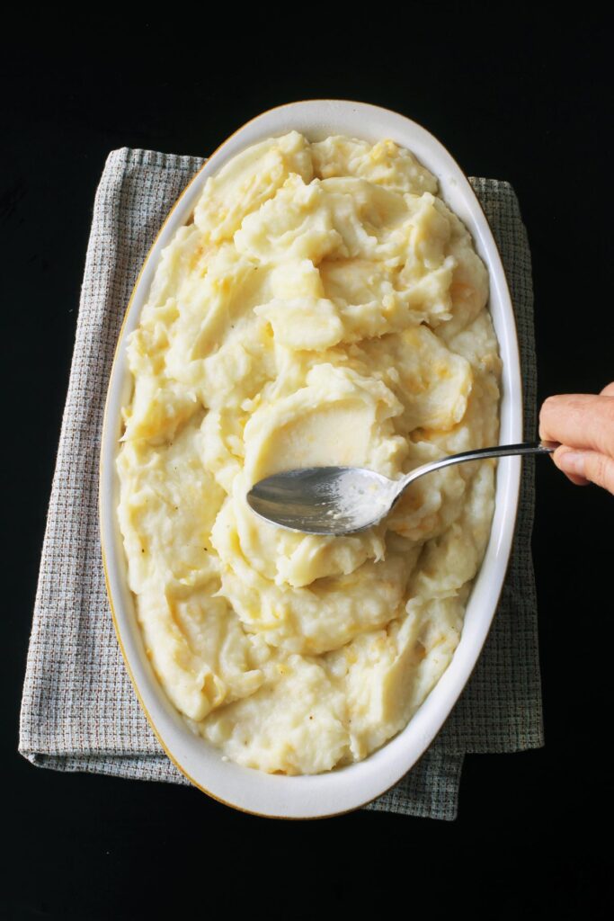 smoothing the mashed potato topping