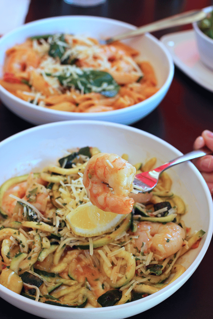 shrimp on fork over bowl of zoodles