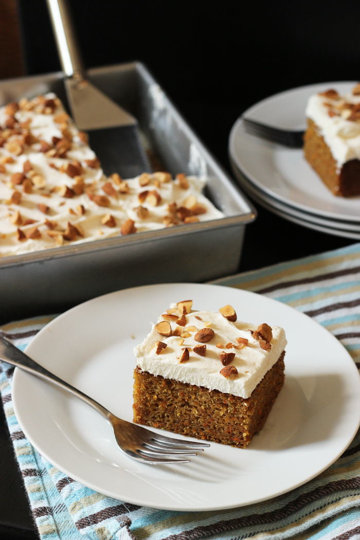 plates of carrot cake next to full sheet cake