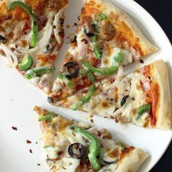 baked supreme pizza sliced on plate