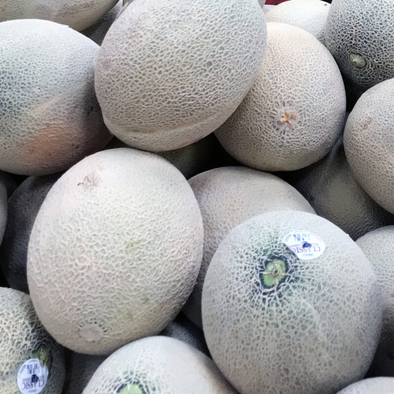 stack of canteloupe melons in store.