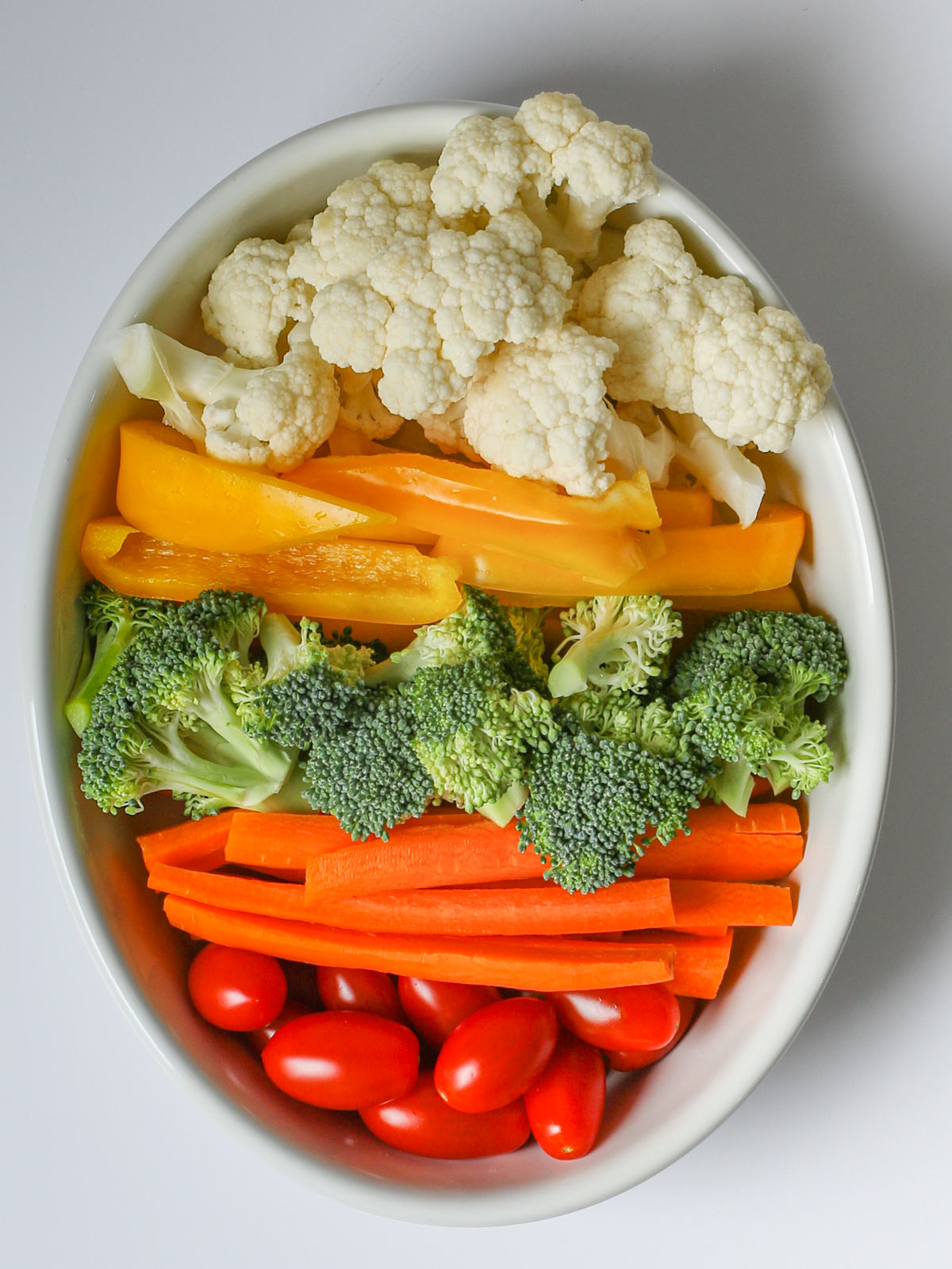 small white platter of veggies, resembling an easter egg.