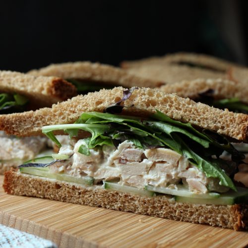 cut side view of chicken salad sandwich with cucumber