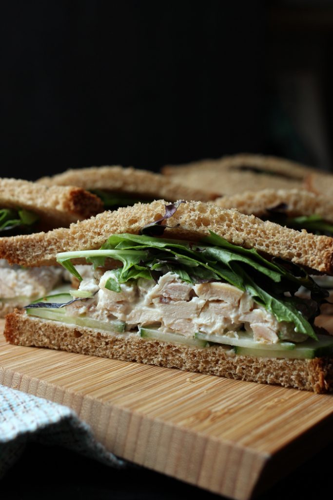 cut side view of chicken salad sandwich with cucumber