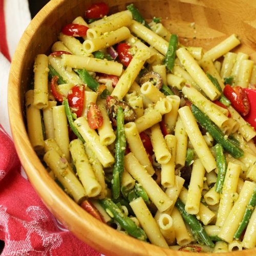 A bowl filled with pasta and vegetables, with Pesto