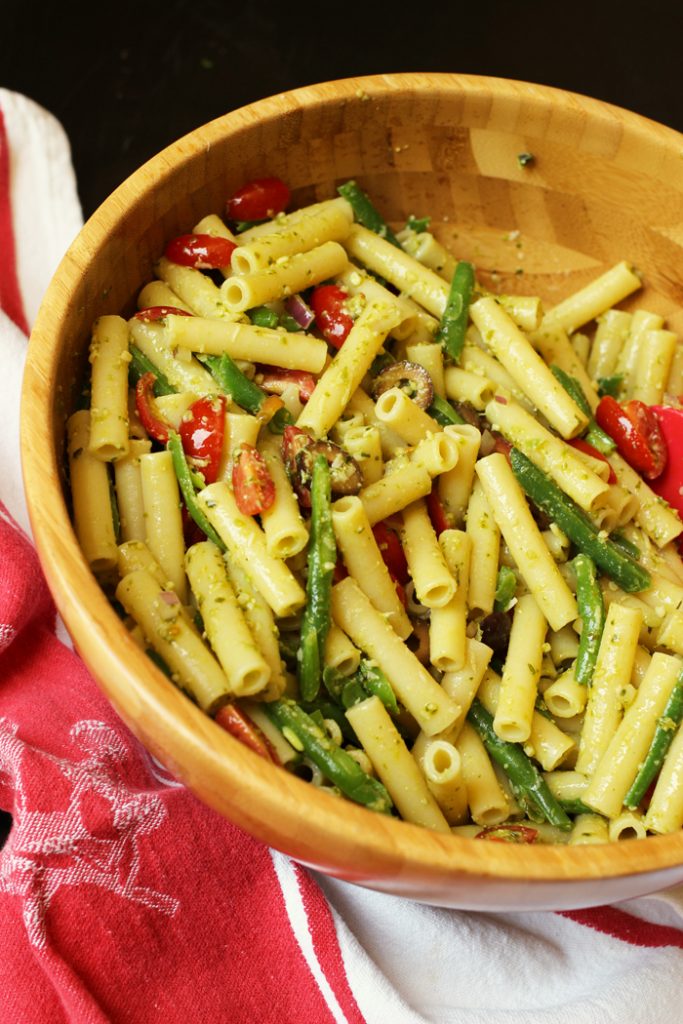 A bowl filled with pasta and vegetables, with Pesto