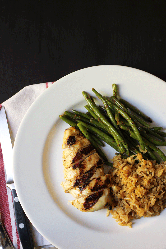 chicken breast on a plate with green beans and rice