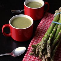mugs of soup on a table, with asparagus