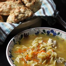 A bowl of Chicken Noodle, with biscuits