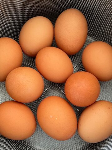 brown eggs in a metal basket.
