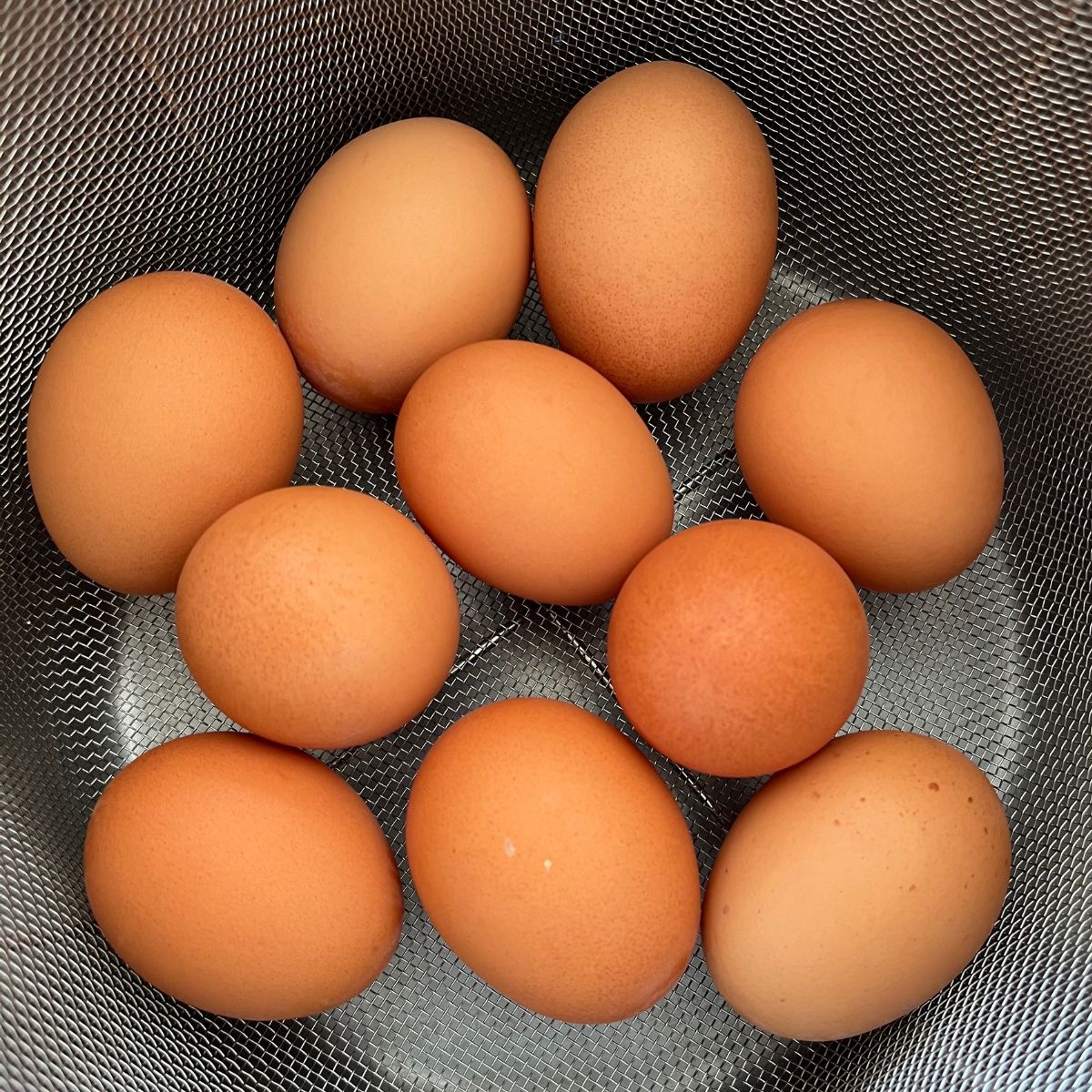 brązowe jajka w metalowym koszu.