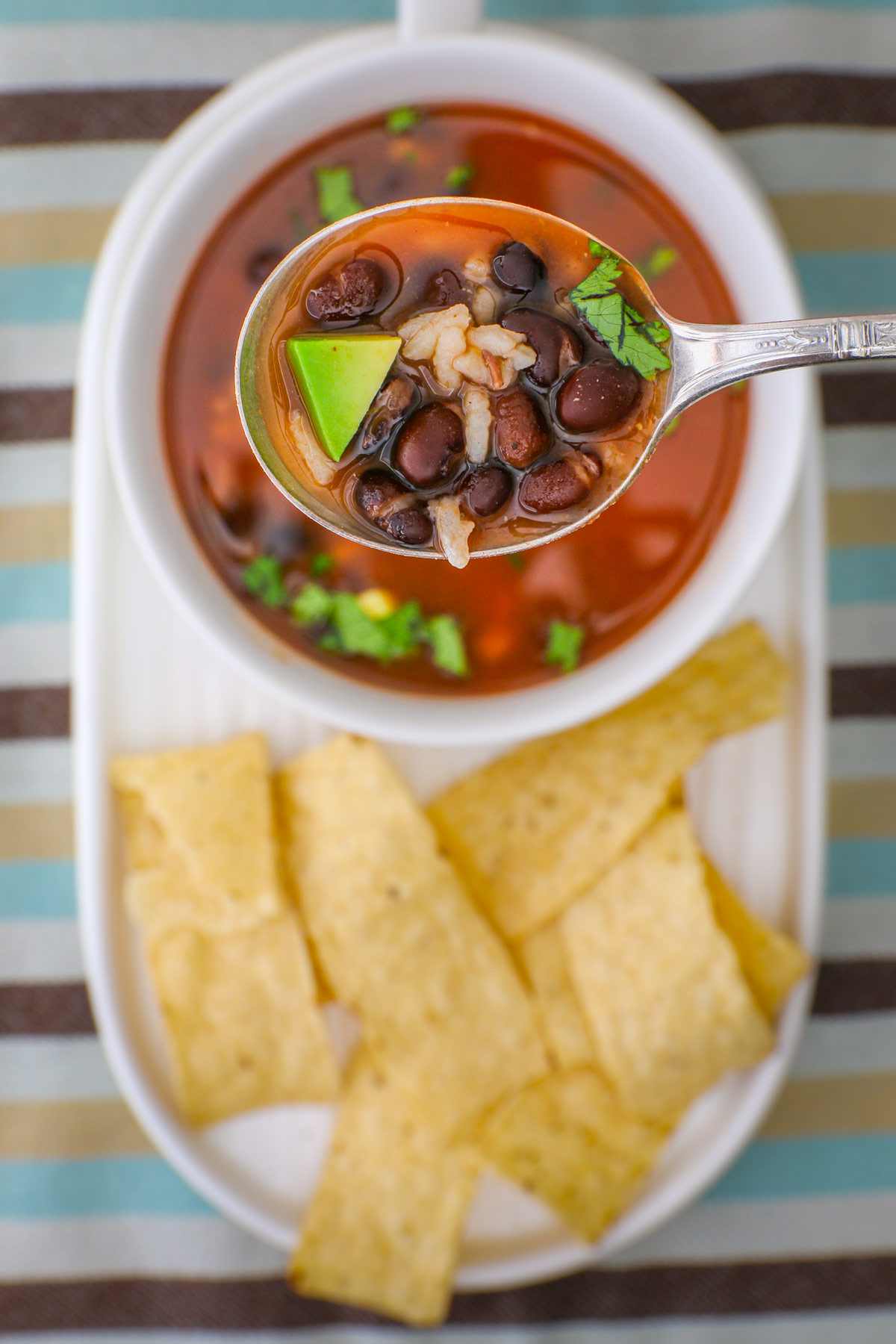 overhead shot of rice and bean soup with chips on the plate.