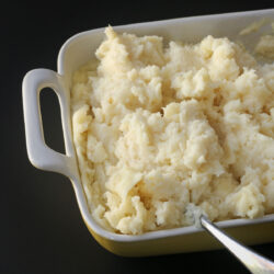 close up of mashed potatoes in rectangular baking dish.
