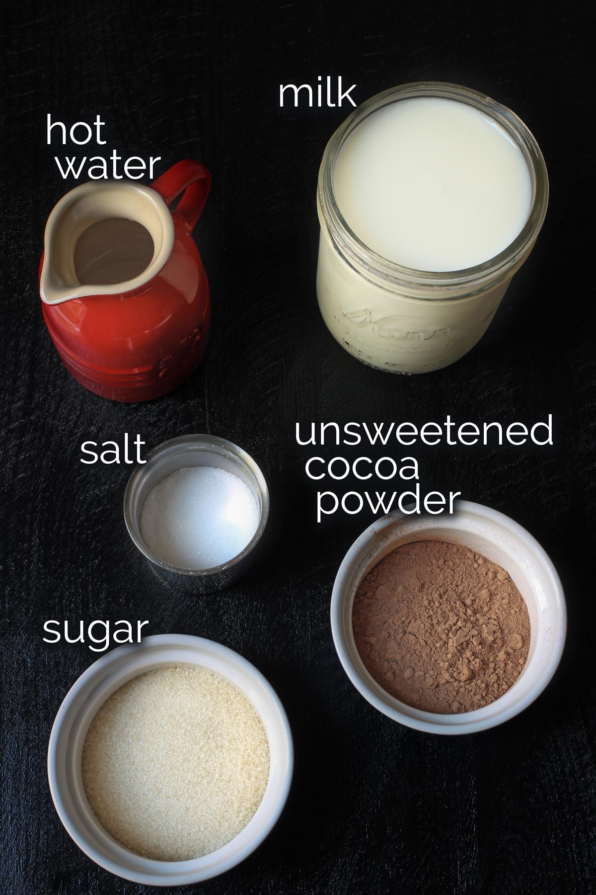 ingredients for stovetop hot cocoa measured into dishes and laid out on table top.