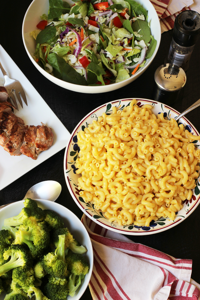 table set with mac and cheese salad pork and broccoli