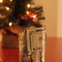jar of money with christmas tree in background