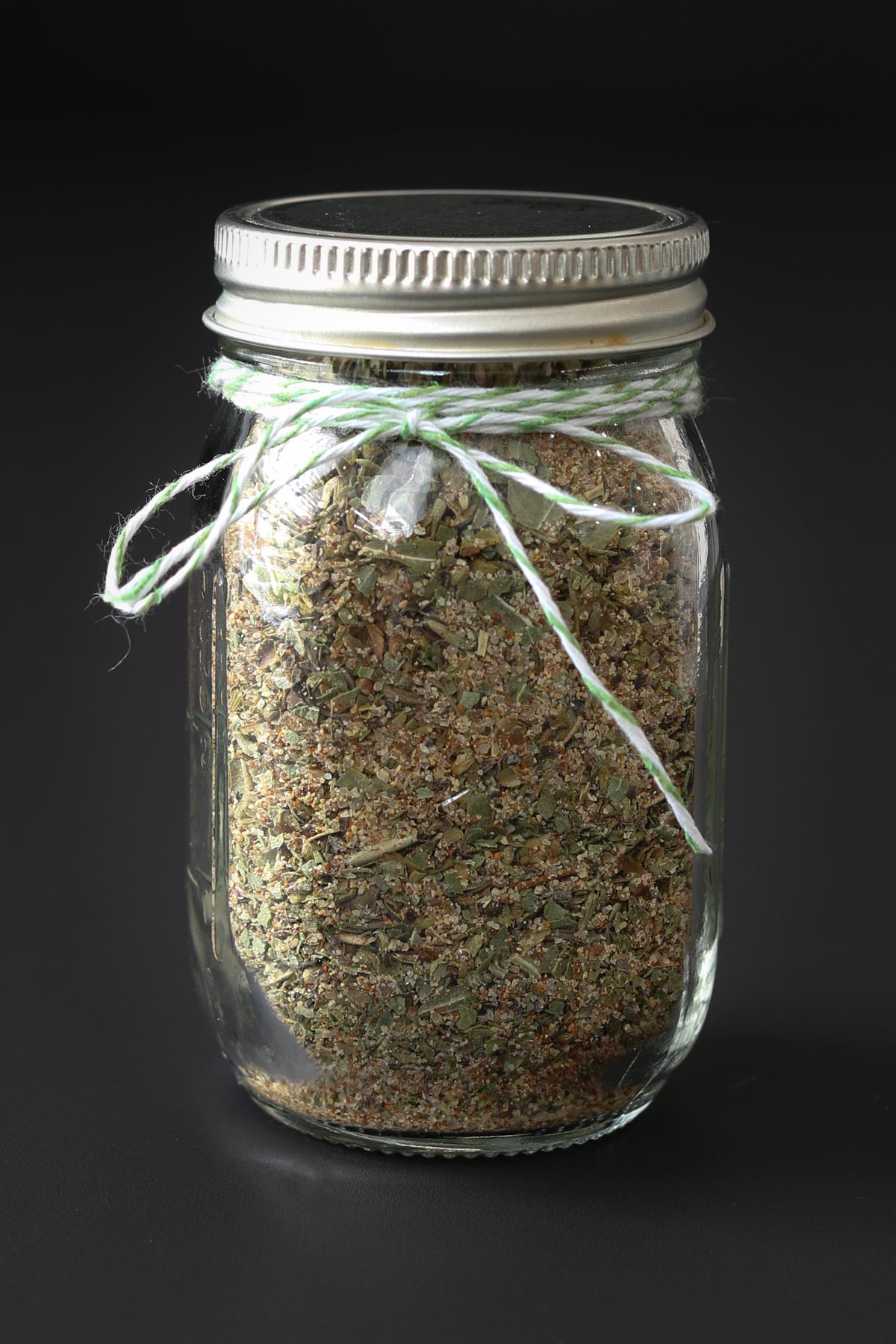 seasoned salt in a small glass mason jar with silver lid and blue twine around the neck.