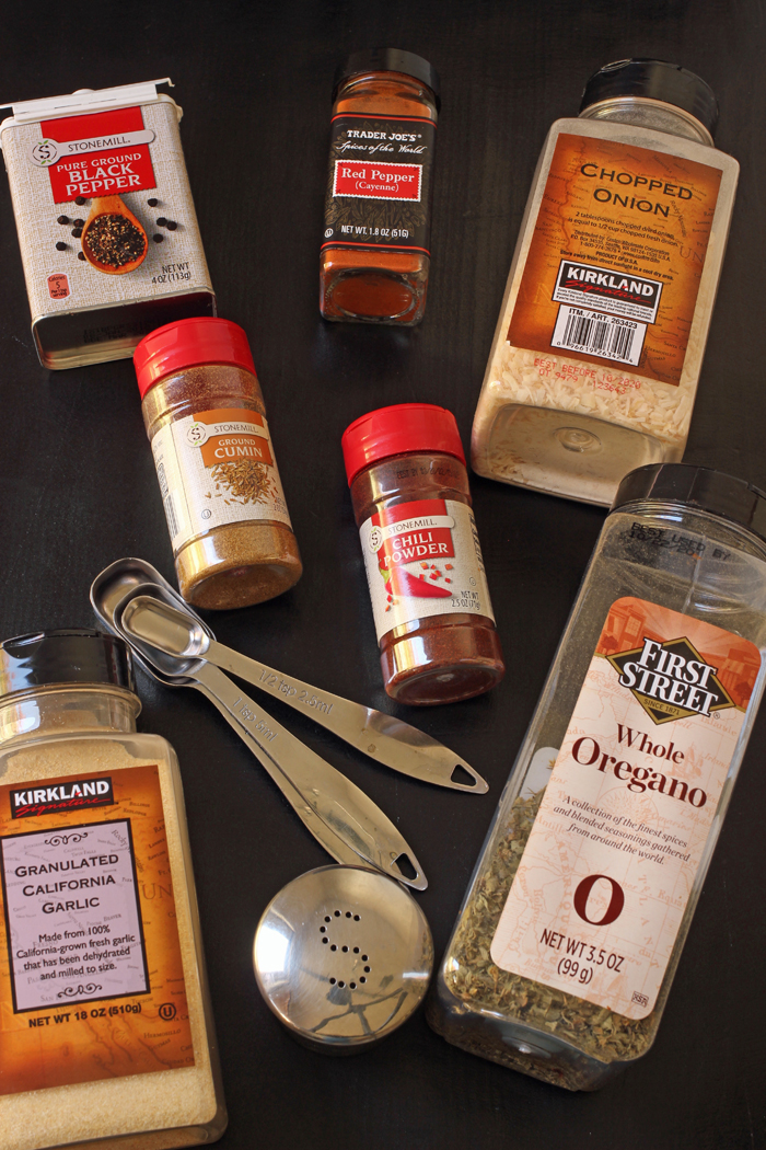 containers of spices and herbs with measuring spoons