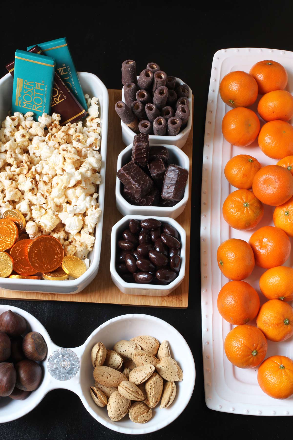fruit, chocolate, nuts, and popcorn laid out on platters.