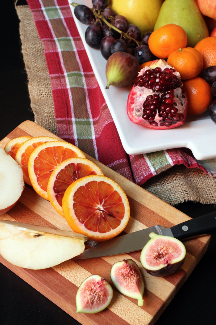 sliced orange pear and fig on cutting board with knife