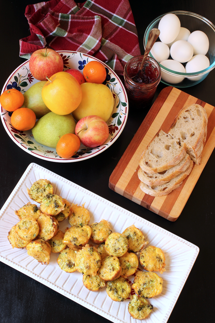 breakfast table set with fruit, eggs, bread, and quinoa egg bites