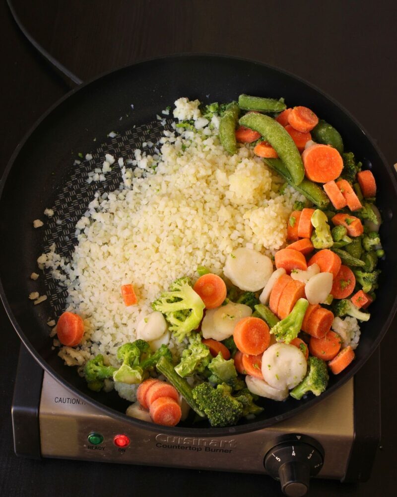 cauliflower rice and stir fry veggies in skillet.