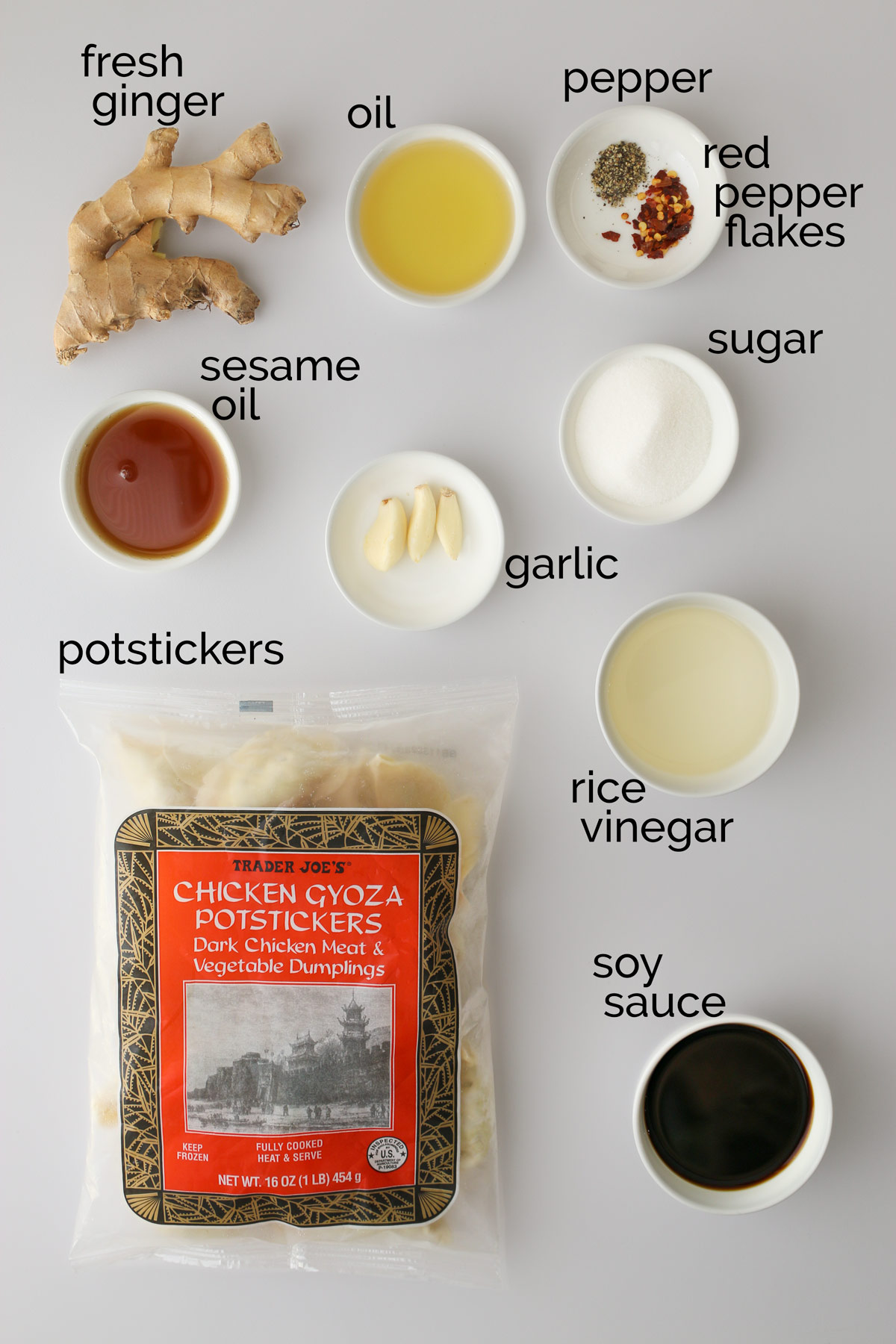 ingredients for potstickers and dipping sauce laid out on white counter.