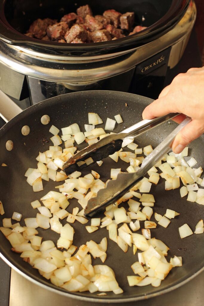 sautéing onions in drippings in pan