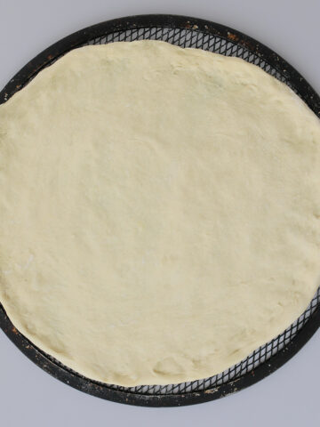 the finished dough on a pizza screen.