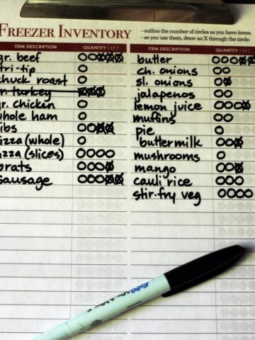 closeup of freezer inventory on laminated worksheet on clipboard.